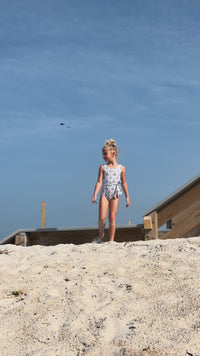 Girl on beach in Indie Blue Tie One Piece in Bluebell Print